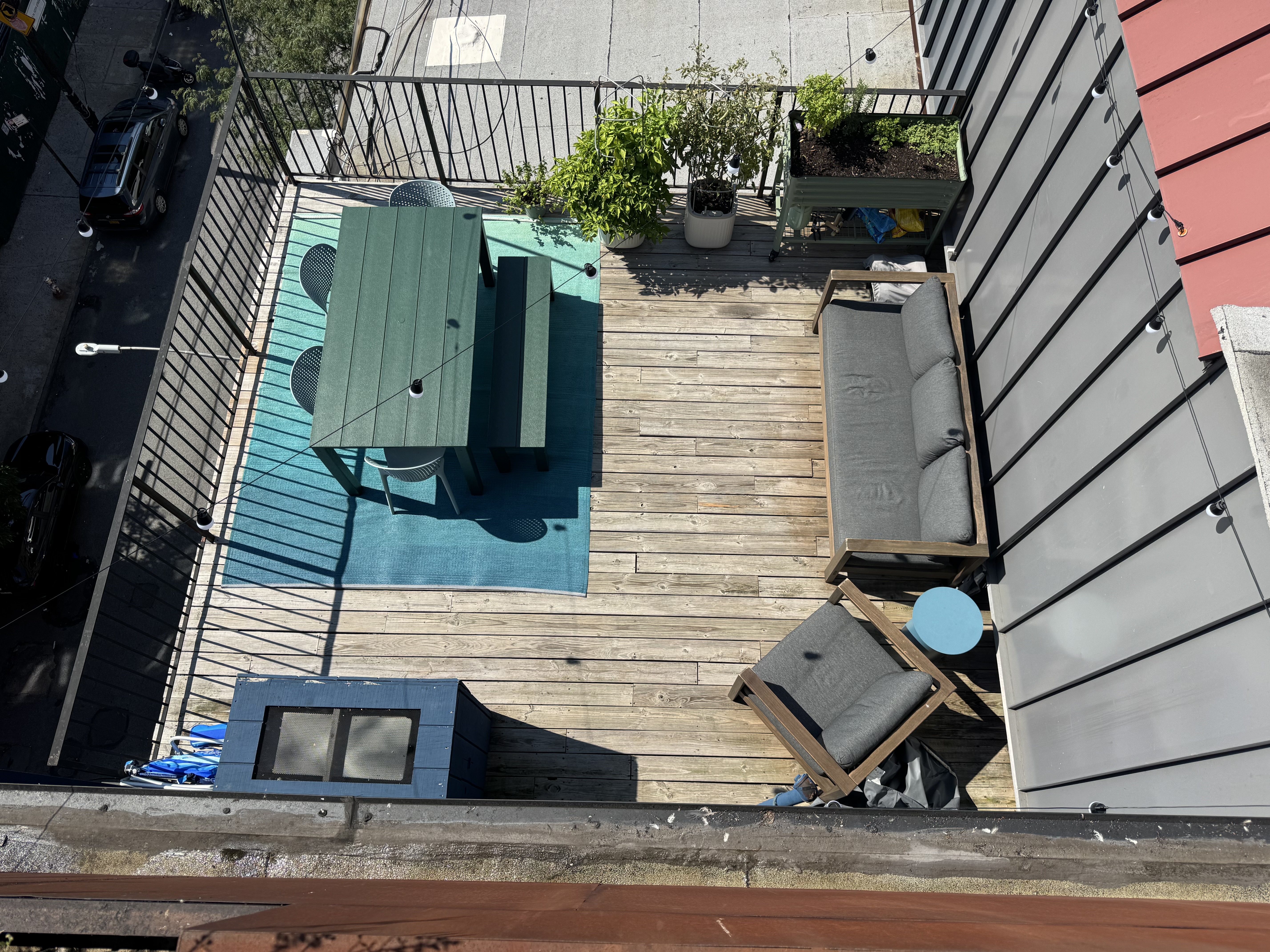Bird's-eye view of the full private terrace showing the dining set, lounge seating, rugs, and planters